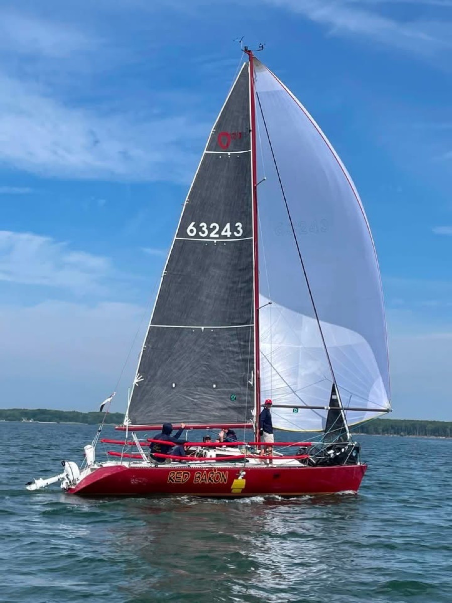S/V Red Baron, a red Olson 29 with sail number 63243, racing under spinnaker